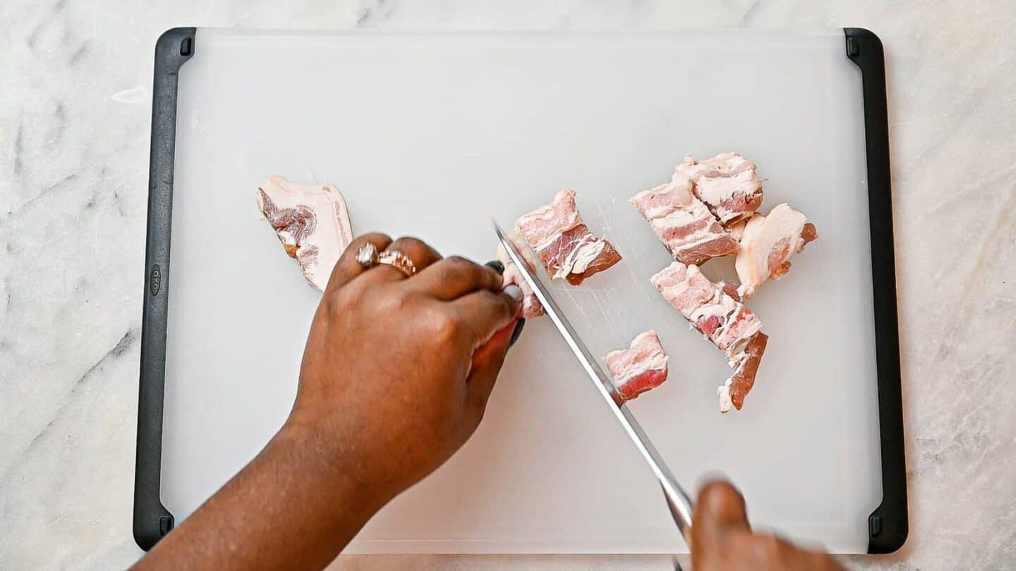 hands chopping bacon