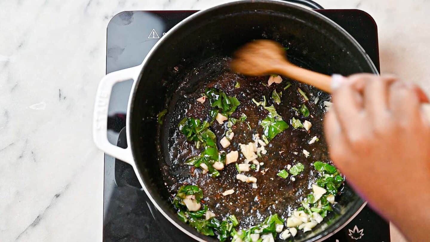 stirring garlic and basil in pan