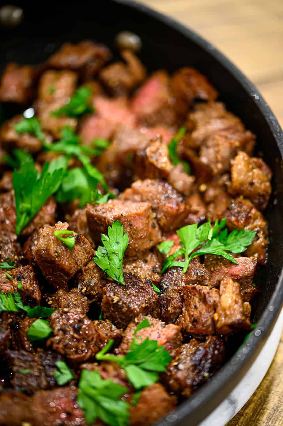 Garlic Butter Steak Bites in a pan with parsley. 