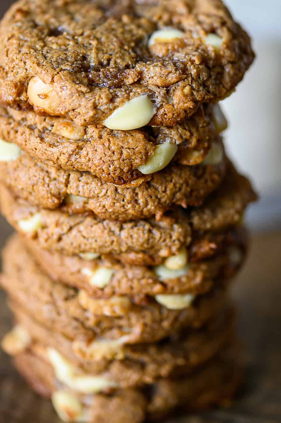 Keto white chocolate macadamia nut cookies stacked on top of each other.