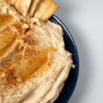 garlic hummus with pita chips on top