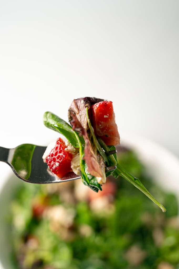 Strawberry pecan chicken salad on a fork.