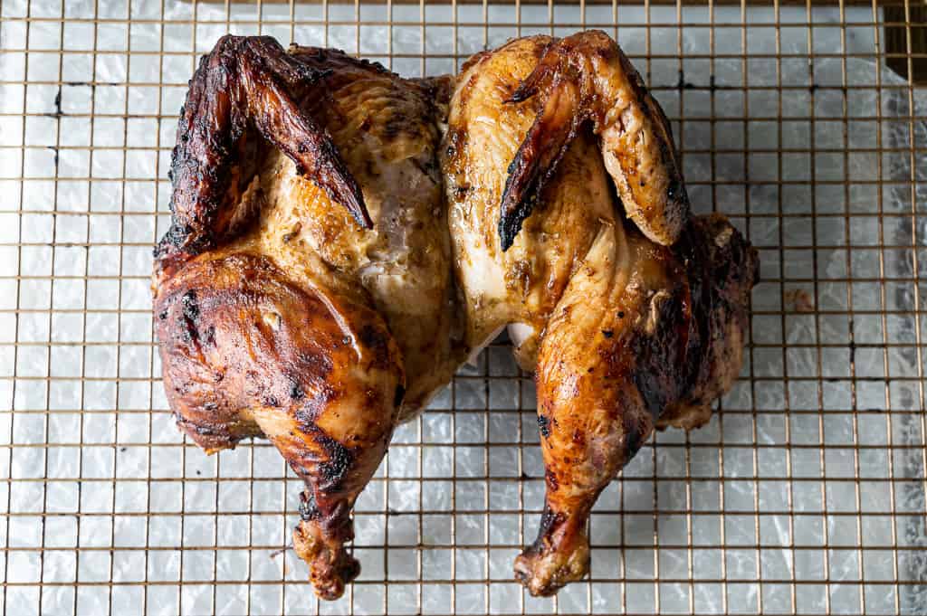 spatchcocked chicken on a wire rack.