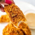 Chicken tenders held up by hands with pink nails