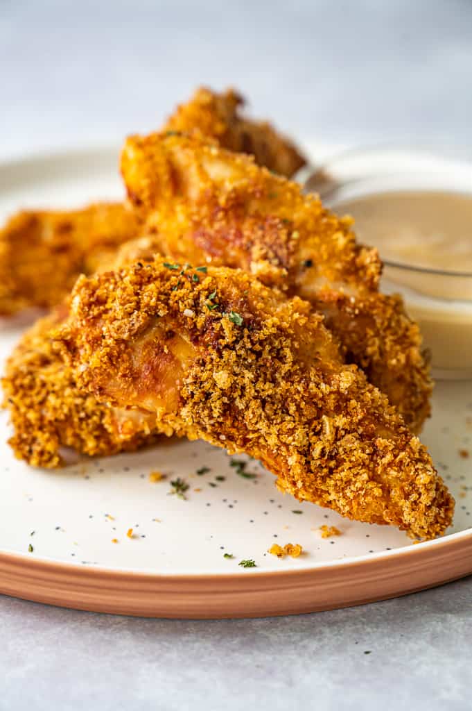 Chicken tenders on a plate with dipping sauce.