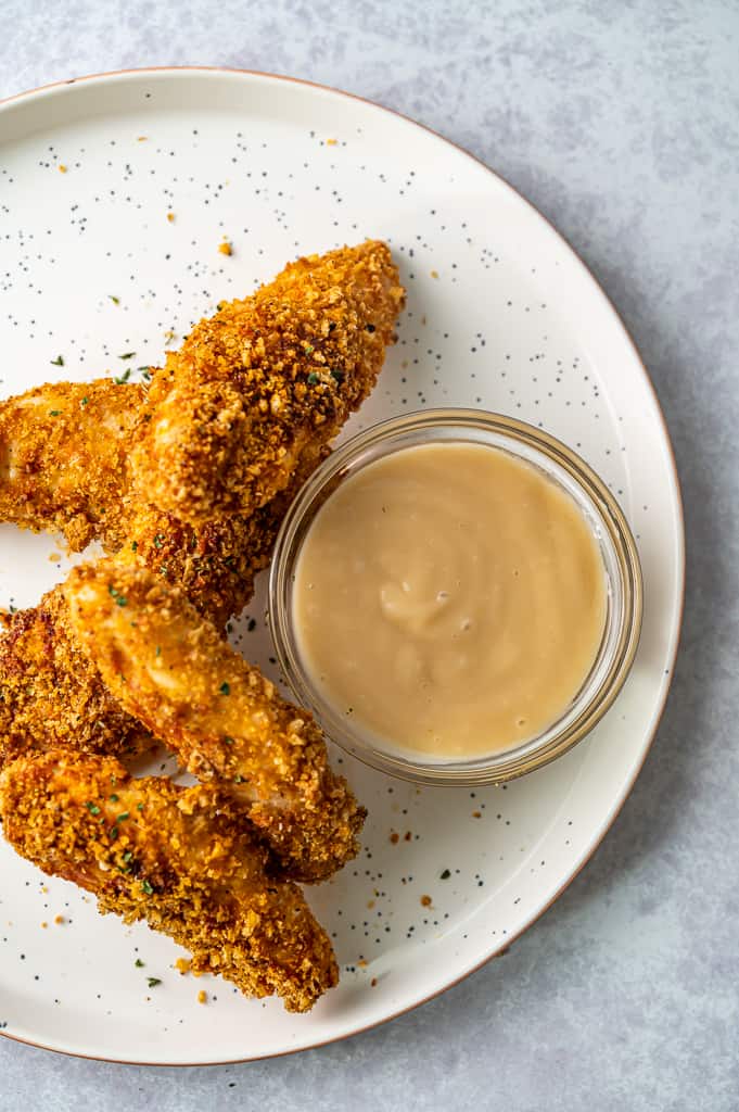 Keto chicken tenders on a plate with dipping sauce.