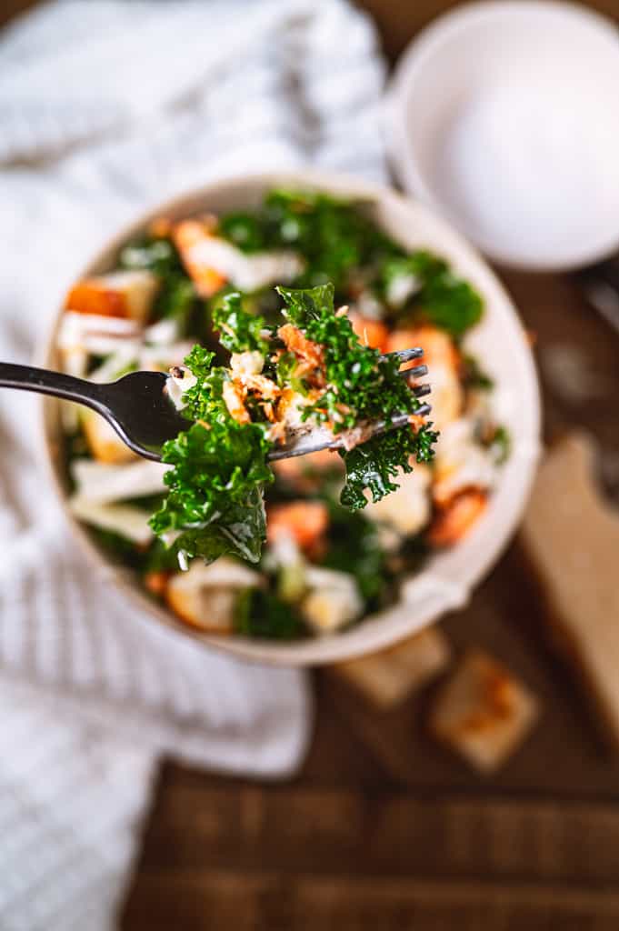 salmon caesar salad gathered on a fork