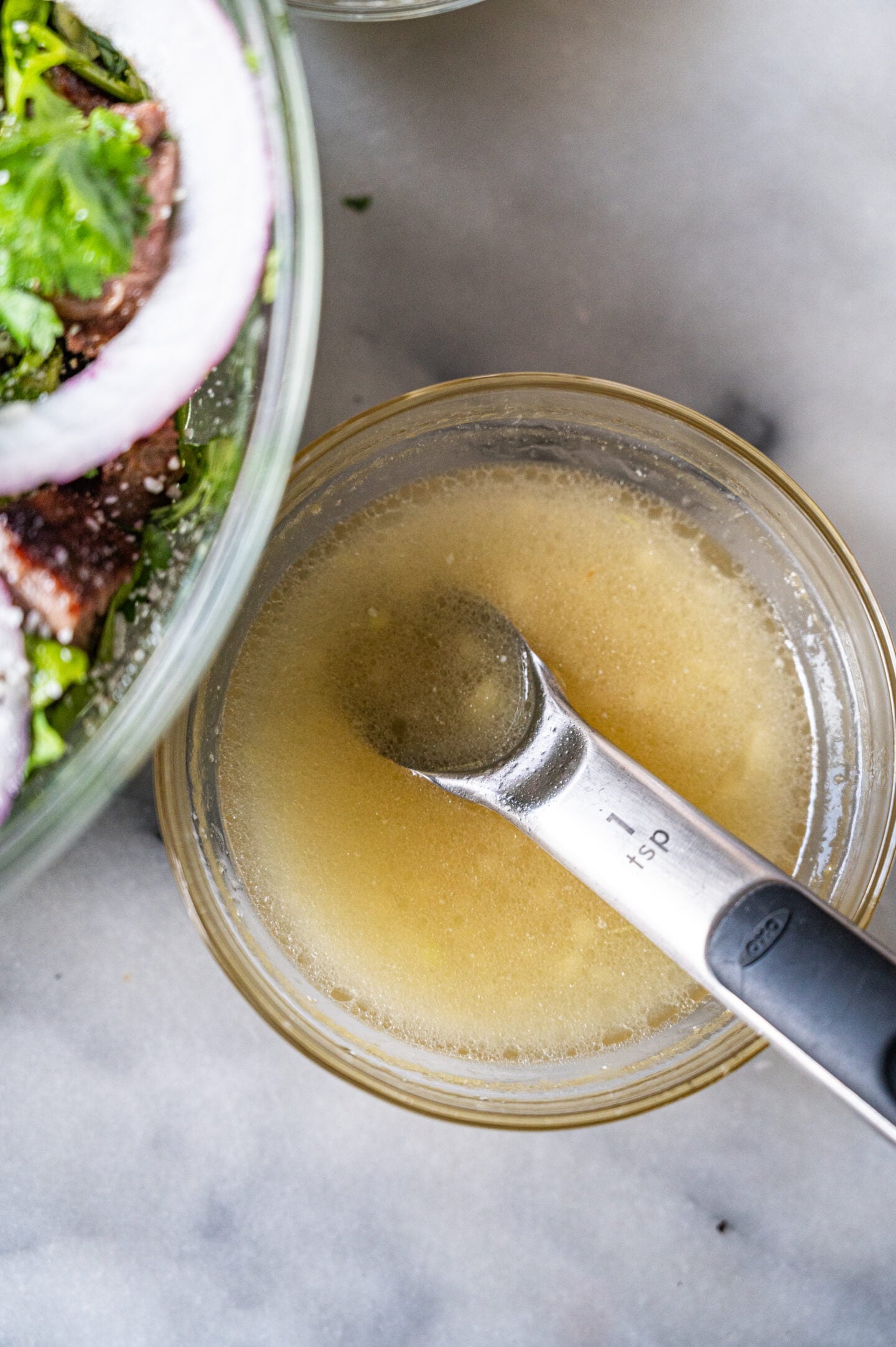 apple cider vinaigrette in a bowl next to a salad