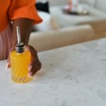 glass bitters bottle with person holding simple syrup