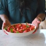 holding bowl of watermelon salad
