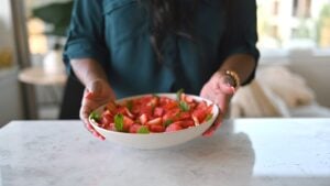 holding bowl of watermelon salad