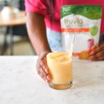 Saturn cocktail in mila's hands on a counter with Truvia Sweet Complete in a package behind.