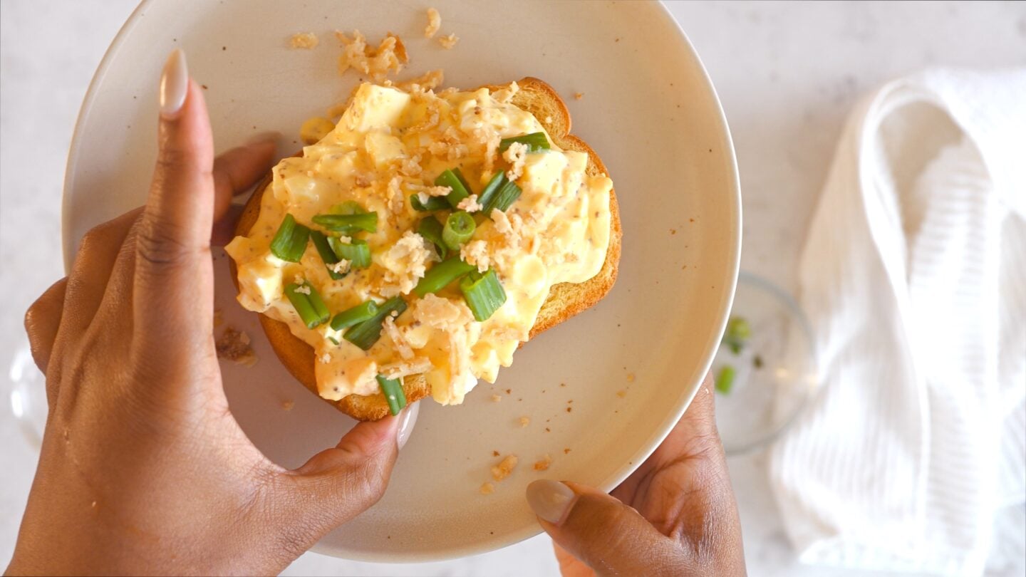 Egg salad spread on bread on a gray plate
