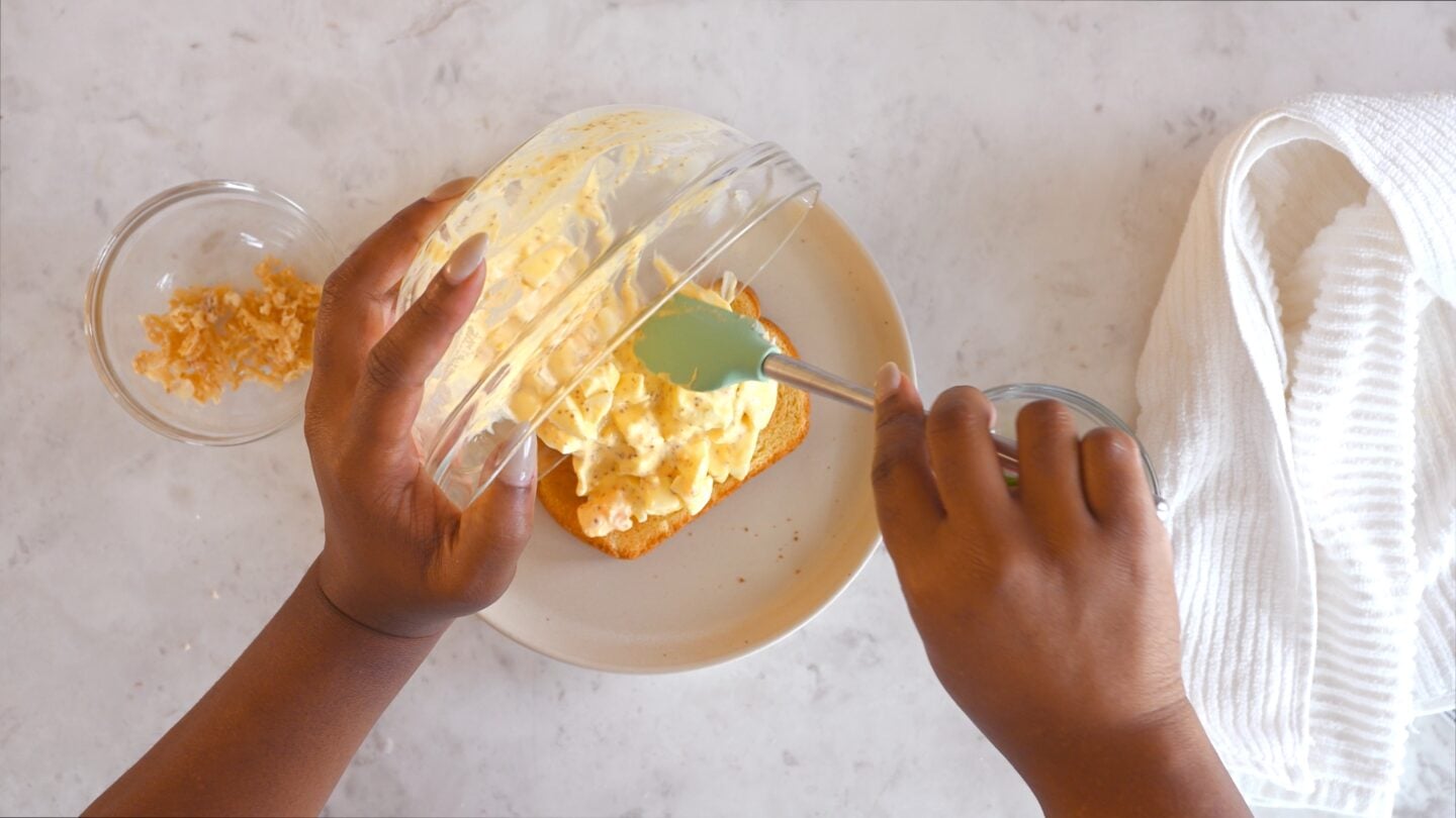 Egg salad spread onto sprouted grain bread.
