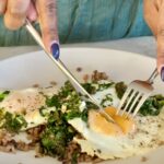 Egg and Pesto Breakfast Grain Bowl cut with a fork and knife