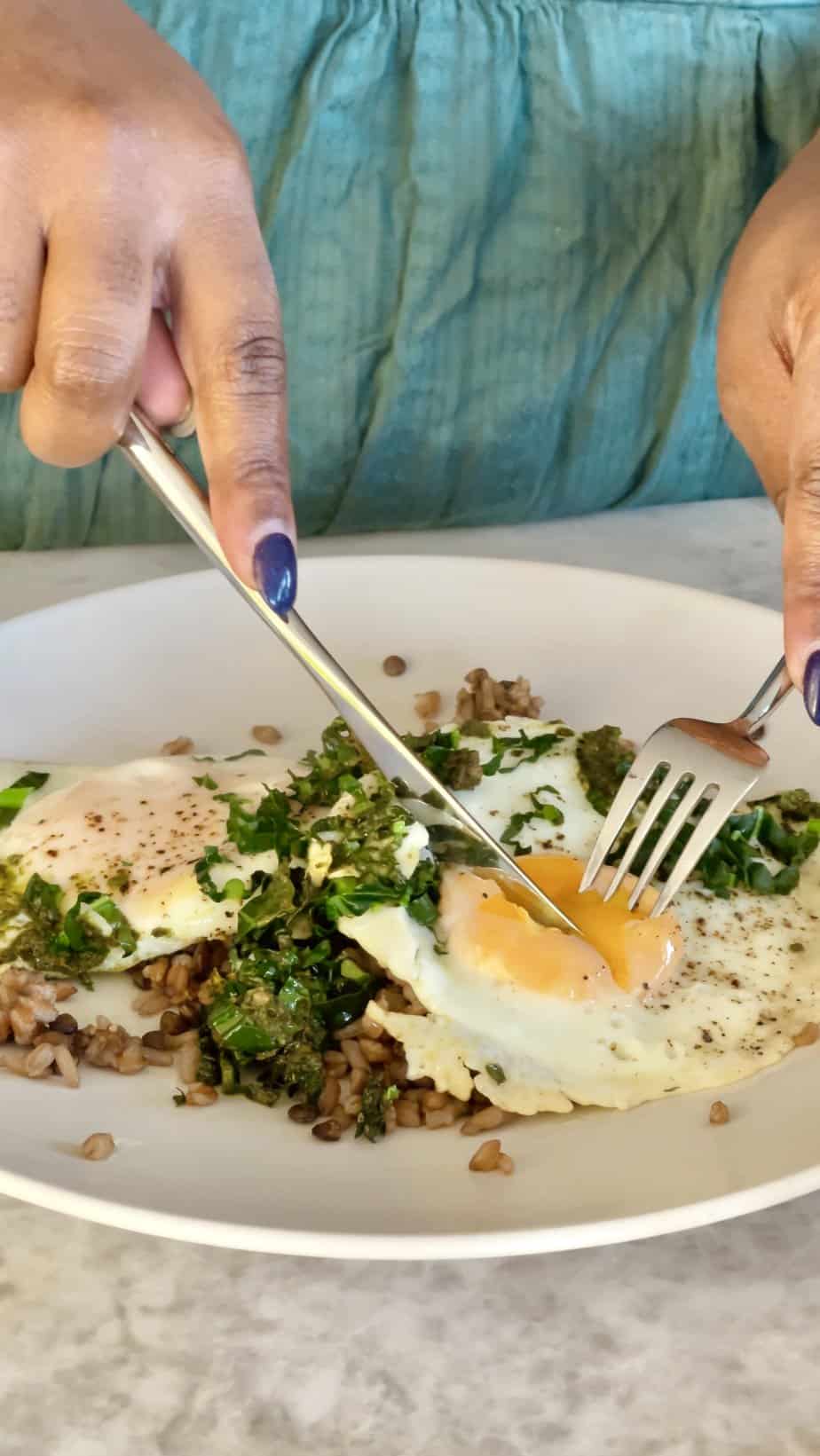 Egg and Pesto Breakfast Grain Bowl cut with a fork and knife