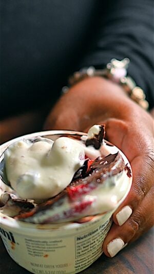 Spoonfull of yogurt with strawberries and chocolate