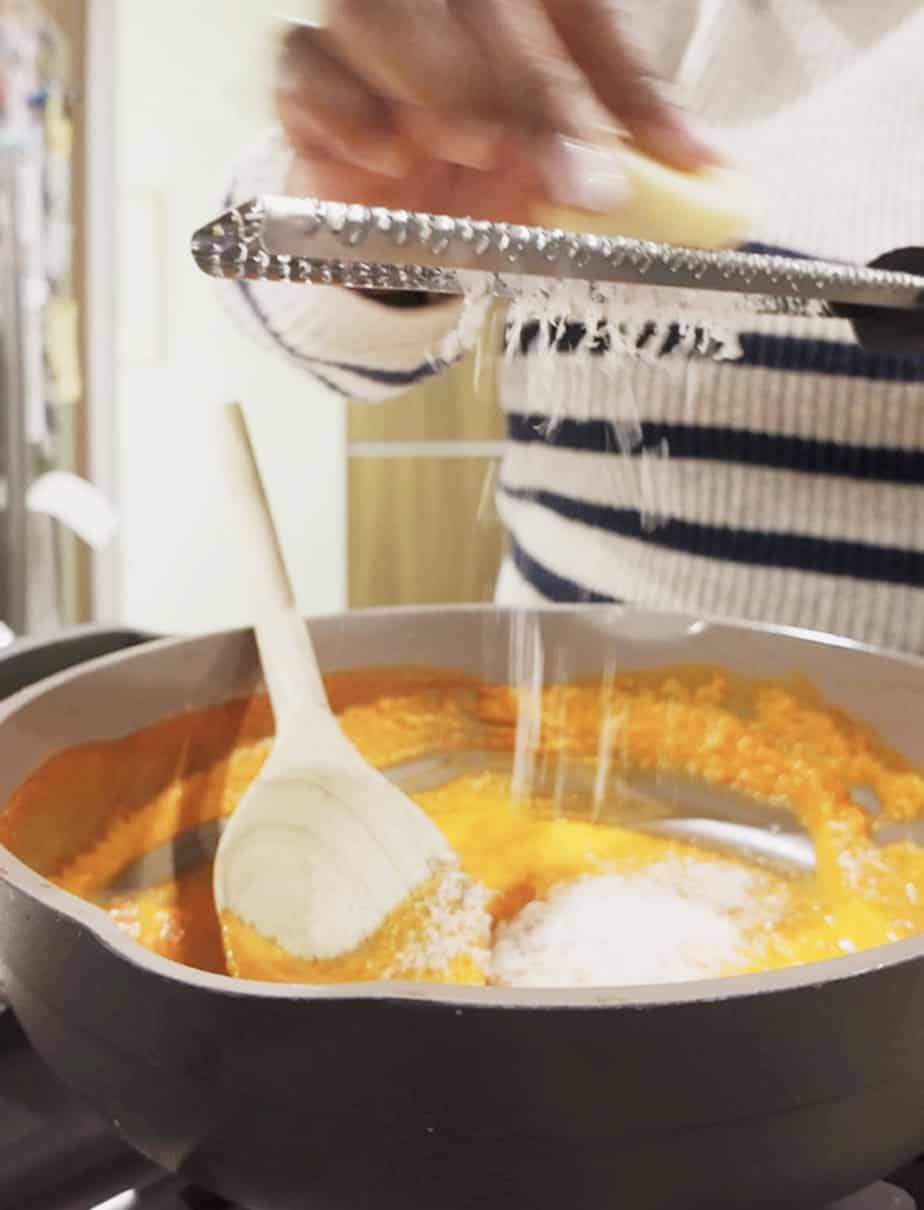 grating parmiggiano reggiano over sauce