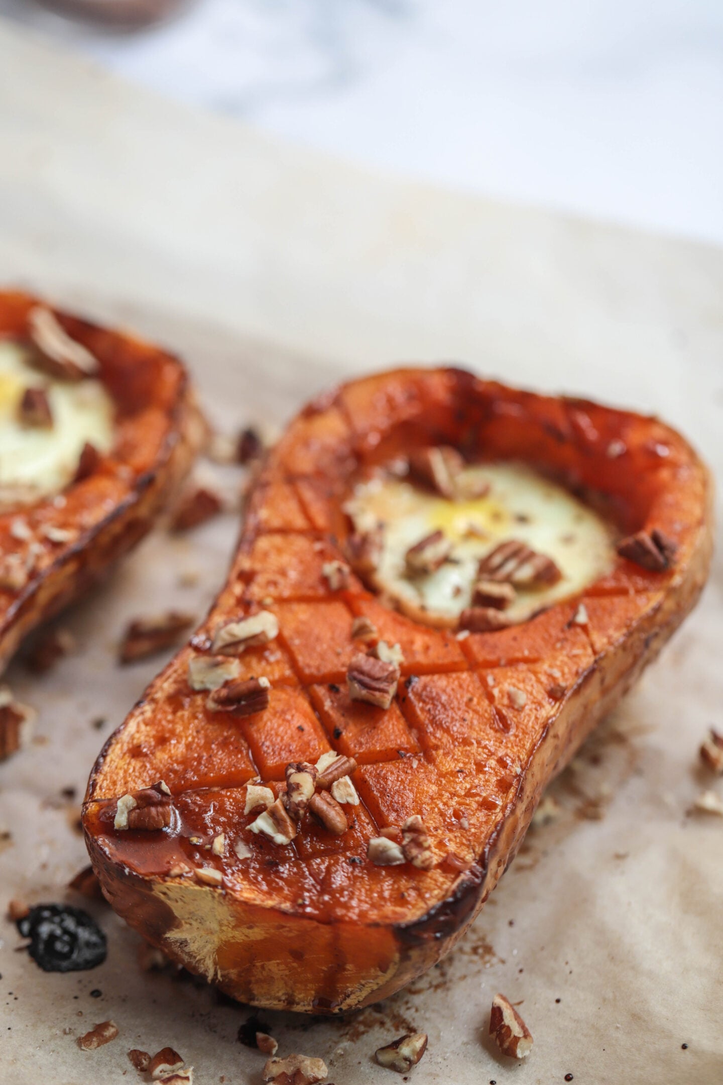 Buttnernut squash on a baking sheet with eggs.