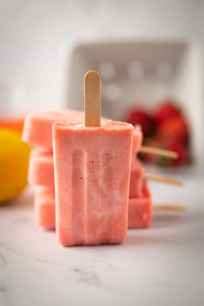 Strawberry lemonade ice pops stacked on top of each other.